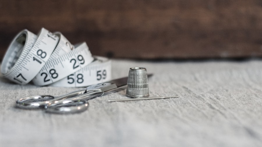 Tailor's scissors, measuring tape, thimble and needle on the cutting table